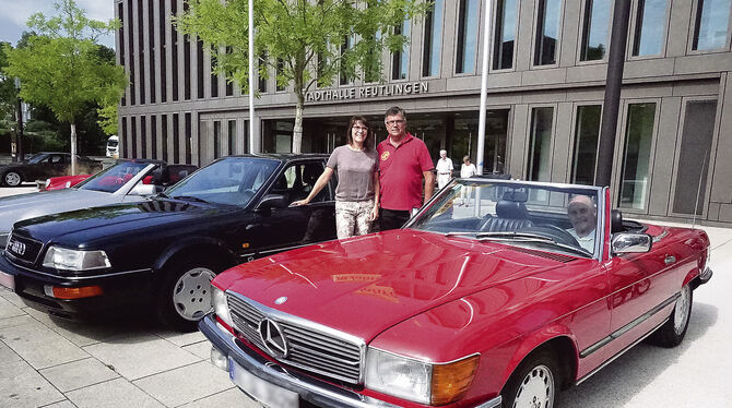 Tanja Ulmer und Dietmar Scheib  zwischen einem Audi V8 und einem roten 300 SL, in dem es sich sein Besitzer Heinz Heiligenmann b