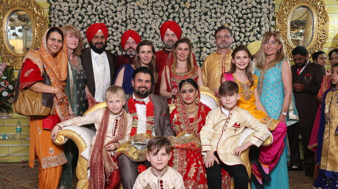 Das farbenprächtige Gruppenbild der Hochzeitsgesellschaft täuscht: Nur die Braut in der Mitte ist Inderin. Der Rest gehört zur F