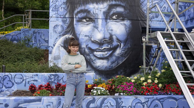 Anna Vollrath vor ihrem Porträt auf der Atelier-5-Wand von Florian Kaiser. Die 14-Jährige ist mit ihren Eltern schon seit acht J
