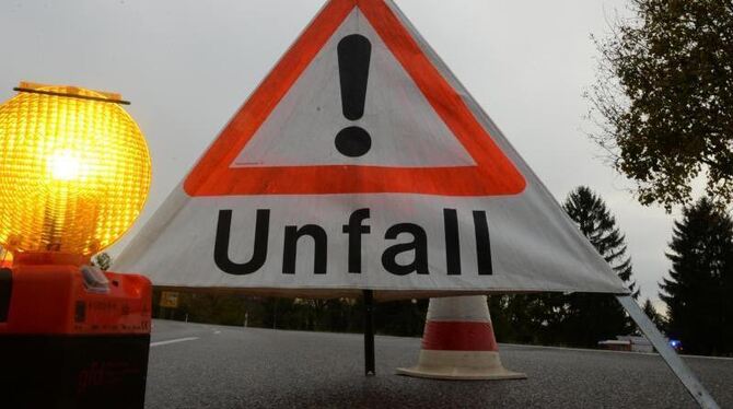 Ein Warndreieck mit der Aufschrift »Unfall« steht auf der Straße