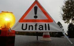 Ein Warndreieck mit der Aufschrift »Unfall« steht auf der Straße