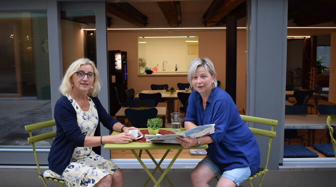 Besprechung vorm Haus mit Blick ins Café des Familienzentrums: die Leiterin Christa Herter-Dank (links) und ihre Mitarbeiterin M