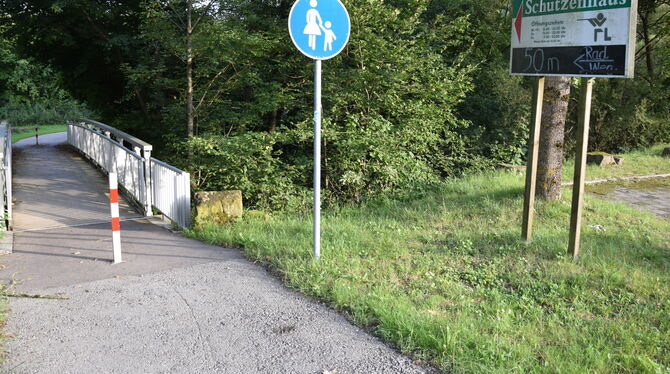 Zarter Kreidehinweis auf den besseren Radweg in die Ortsmitte von Dußlingen, der beschattet entlang der Steinlach verläuft.