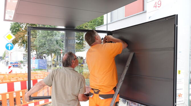 In den schicken Haltestellen-Häuschen werden Fahrplanvitrinen montiert.