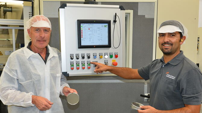 Geschäftsführer Richard Hönes (links) und Pedro Martins, Meister in der Stanzerei, führen einen neuen Tafelstanzautomaten des Do