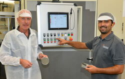 Geschäftsführer Richard Hönes (links) und Pedro Martins, Meister in der Stanzerei, führen einen neuen Tafelstanzautomaten des Do