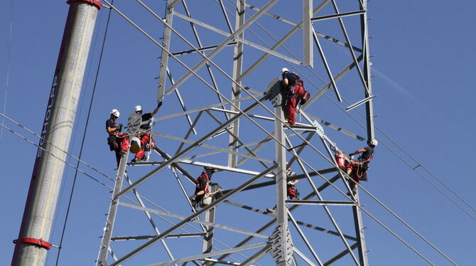 Die 55 bis 70 Meter hohen Strommasten wachsen Stück für Stück: Ein Kran hebt ein rund zwölf Tonnen schweres Bauteil in die Höhe