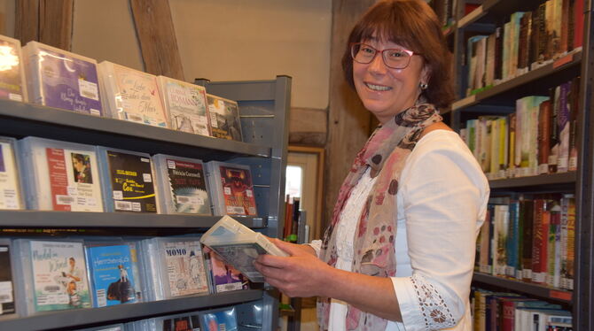 Ulla Krämer vor dem bedienerfreundlichen neuen Regal für Hör-bücher in der  Stadtbücherei  Münsingen. Foto: Oelkuch