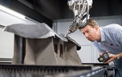 Ein Trumpf-Mitarbeiter kontrolliert die Arbeit eines Lasers am Werkstück. Foto: Trumpf