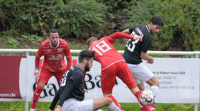 Jules Stern von der SG Reutlingen (Mitte, rotes Trikot) kommt gegen Derendingens Torschützen Jonas Quaas (sitzend) und Philipp B