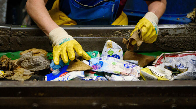 Eine Mitarbeiterin sortiert an einem Fließband Verpackungsabfälle. FOTO: DPA Eine Mitarbeiterin sortiert an einem Fließband Verpackungsabfälle. FOTO: DPA