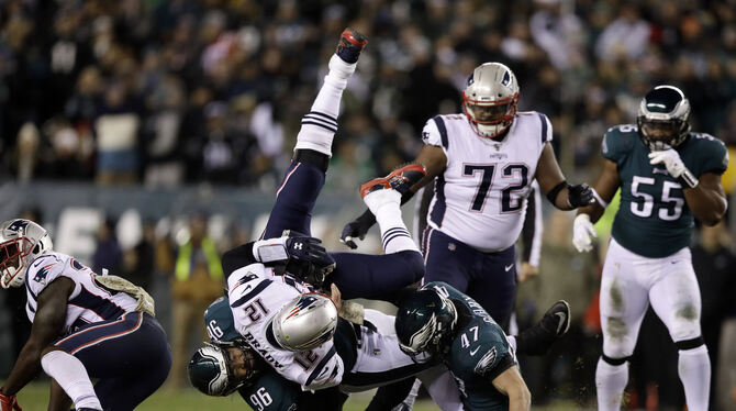 Quarterback Tom Brady von den Patriots (vorne) wird von Derek Barnett (links) and Nate Gerry von den Eagels zu Boden gerissen. Quarterback Tom Brady von den Patriots (vorne) wird von Derek Barnett (links) and Nate Gerry von den Eagels zu Boden gerissen.