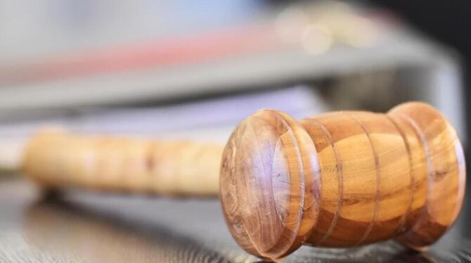 Ein Richterhammer liegt auf einer Richterbank Ein Richterhammer liegt auf einer Richterbank