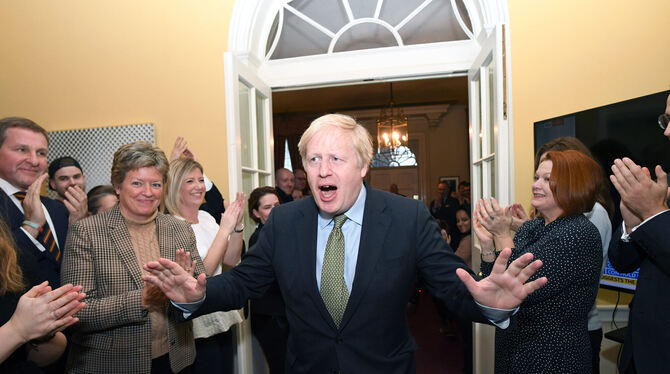 Boris Johnson wird nach seinem Sieg in Downing Street 10 von Mitarbeitern begrüßt.  FOTOS: DPA