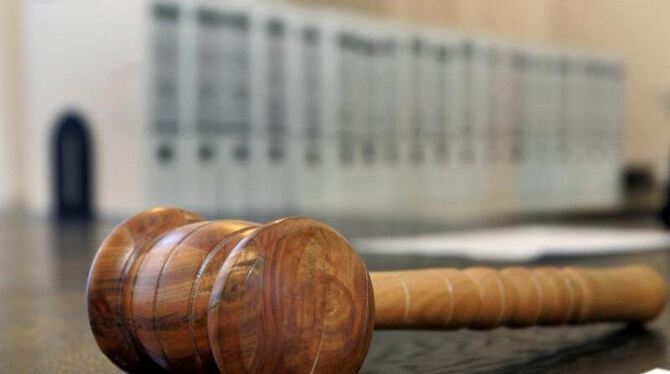 Ein hölzerner Hammer liegt auf einer Richterbank