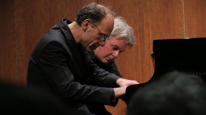 Zur Zugabe mit Ravel nehmen sie an einer Tastatur Platz: Andreas Grau und Götz Schumacher in gemeinsamer Konzentration beim Reut