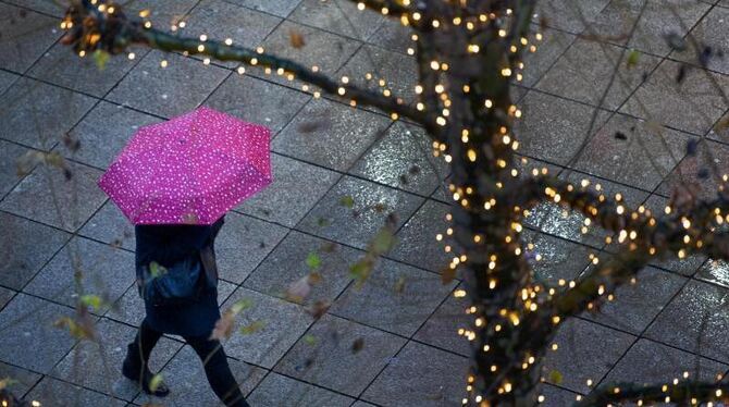 Ein Fußgänger läuft am frühen morgen mit einem Regenschirm Ein Fußgänger läuft am frühen morgen mit einem Regenschirm