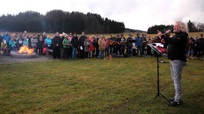 Lagerfeuer und Posaunenklänge: Rund 150 Besucher kamen zum Gottesdienst im Freien mit Ralf Dörr (rechts). FOTO: LEIPPERT