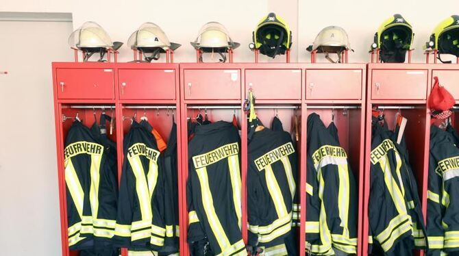 Uniformen der Feuerwehr hängen in einem Schrank