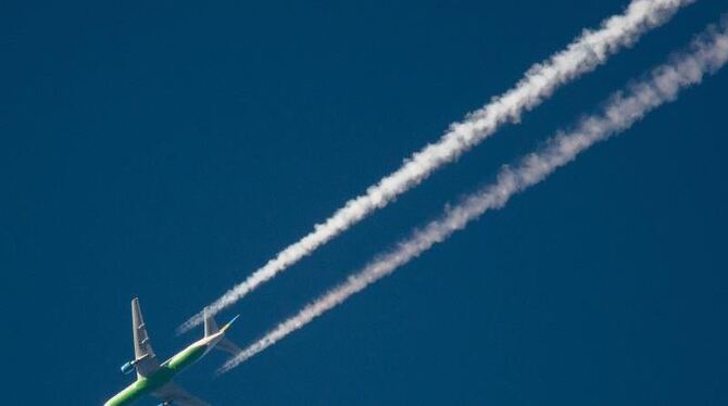 Ein Flugzeug hinterlässt am Himmel Kondensstreifen