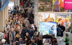 Besucher gehen bei der Reisemesse CMT durch eine Halle