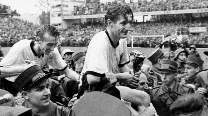 Nach dem Triumph: Horst Eckel (links) und Fritz Walter, der den WM-Pokal in seinen Händen hält, auf den Schultern der Fans.  FOT