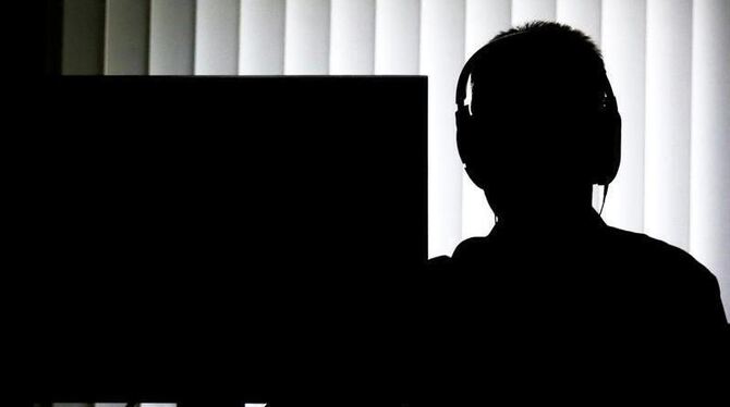 Ein Beamter sitzt für eine Telefonüberwachung vor einem Computer
