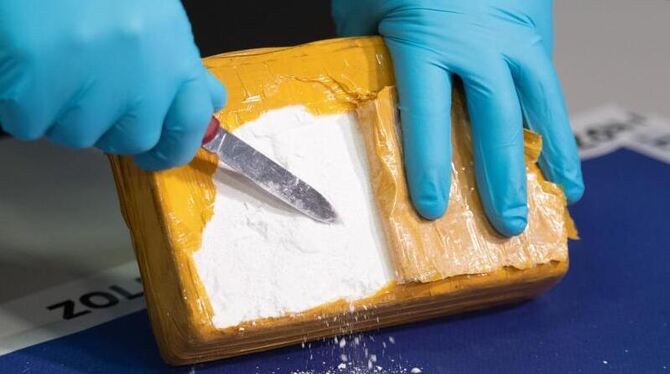 Ein Zollbeamter öffnet ein Paket mit Kokain