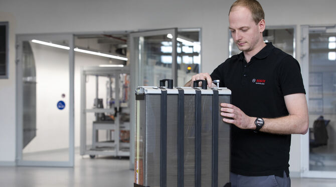 Ein Bosch-Mitarbeiter arbeitet an einem Stack, der als Herzstück einer Brennstoffzelle Wasserstoff in elektrische Energie wandel
