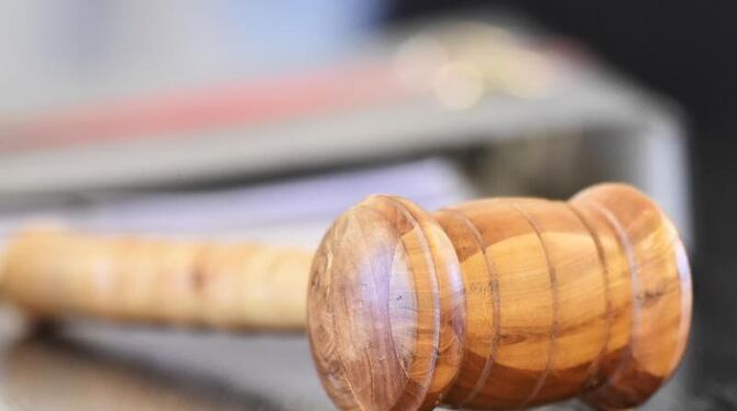 Ein Richterhammer aus Holz liegt auf der Richterbank