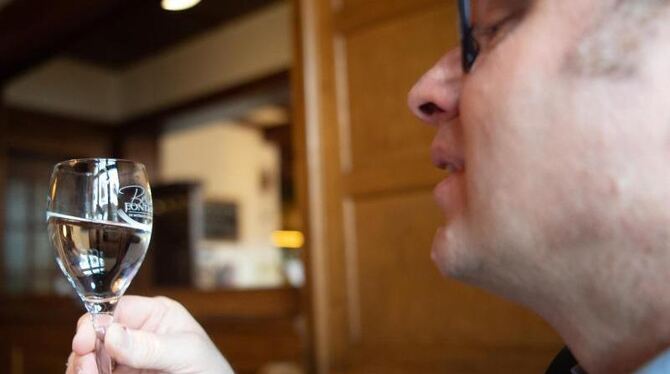 Martin Metzinger schaut in ein Glas Mineralwasser
