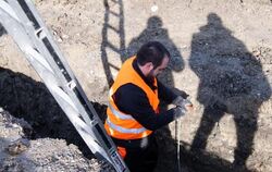 Mitarbeiter im Umbettungsdienst untersucht Baugrube
