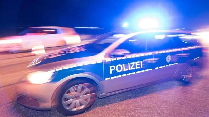 Ein Polizeifahrzeug steht mit Blaulicht auf der Straße