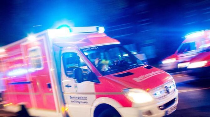 Ein Rettungswagen fährt mit Blaulicht durch eine Straße