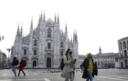 Frau läuft über fast menschenleeren Platz vor dem Mailänder Dom