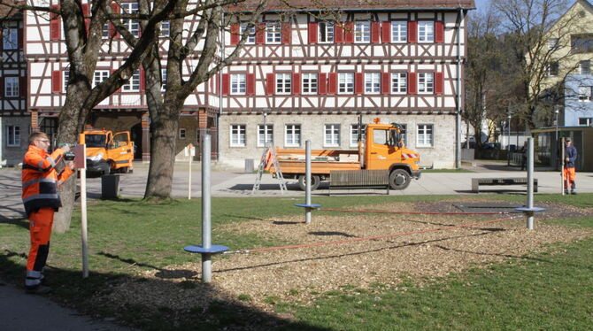 Andreas Schulte (links) und Daniel Benz vom Bauhof montieren Schilder am Münsinger Rathauspark.  FOTO: SCHRADE