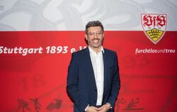 Claus Vogt steht vor einer Wand mit VfB Stuttgart Logo