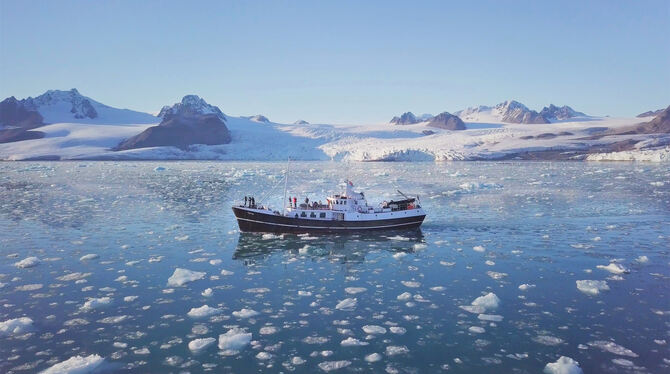 Vom Klimawandel bedrohte Traumlandschaft: Das Schiff der Filmemacher vor der Küste Spitzbergens.  FOTOS: COMFILM