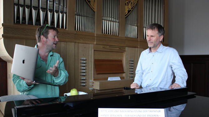 Patrick Bebelaar (links) und Thomas Mandl diskutieren über das Arbeiten mit Laptop. Vorne, auf dem Klavier, ein Schild, das dara