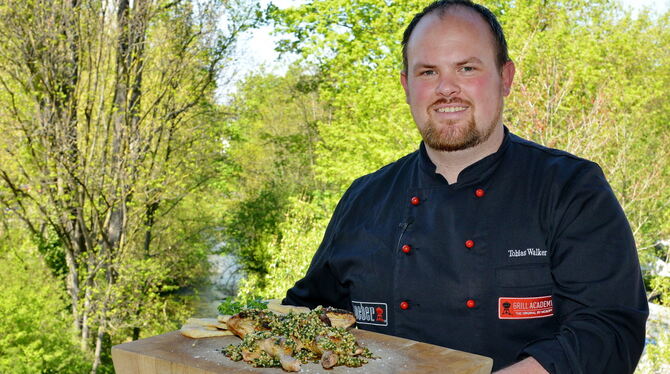 Tobias Walker auf der Terrasse seiner Grillschule in der alten Färberei. Im Hintergrund fließt die Echaz, auf dem Brett präsenti