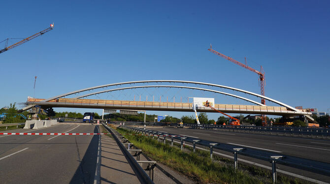 Eine 1500 Tonnen schwere, bereits zusammengebaute Brücke wurde über die Autobahn A8 geschoben und steht nun über den Fahrbahnen.