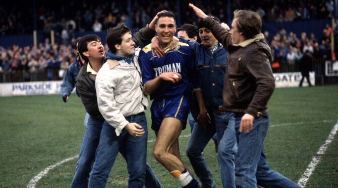 Beliebtes Raubein: Vinnie Jones (Mitte) wird 1988 von Fans nach einem Sieg Wimbledons über Watford gefeiert. FOTO: WITTERS