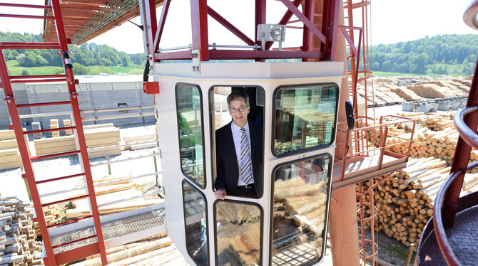 Johannes Schwörer, Präsident des Hauptverbandes der Deutschen Holzindustrie, in der Fahrerkabine des Krans auf dem Holzplatz sei