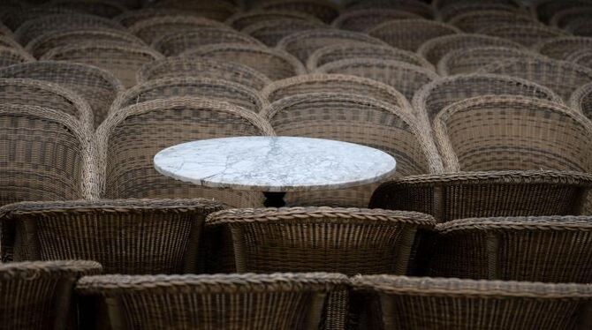 Bistrotisch zwischen leeren Stühlen