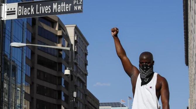 Bei einer Demonstration reckt ein Mann seine Faust in die Luft, um ein Zeichen gegen Rassismus zu setzen.