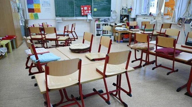 Stühle sind in einem Klassenzimmer auf Tische gestellt