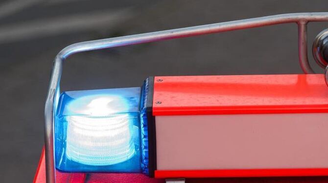 Ein Fahrzeug der Feuerwehr fährt mit Blaulicht über eine Straße
