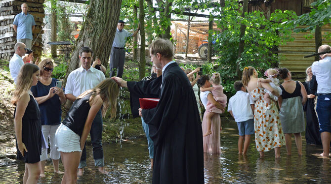 Pfarrer Johannes Eißler tauft eine Konfirmandin im Arbach.  FOTO: KIRCHE