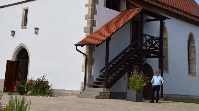 Pfarrer Jörg Conrad steht vor der Veitksirche. Der älteste Teil mit dem Turm soll aus dem 15. Jahrhundert stammen.  FOTOS: SAPOT