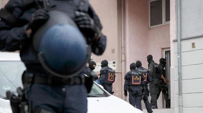 Polizeibeamte vor Hauseingang während Razzia